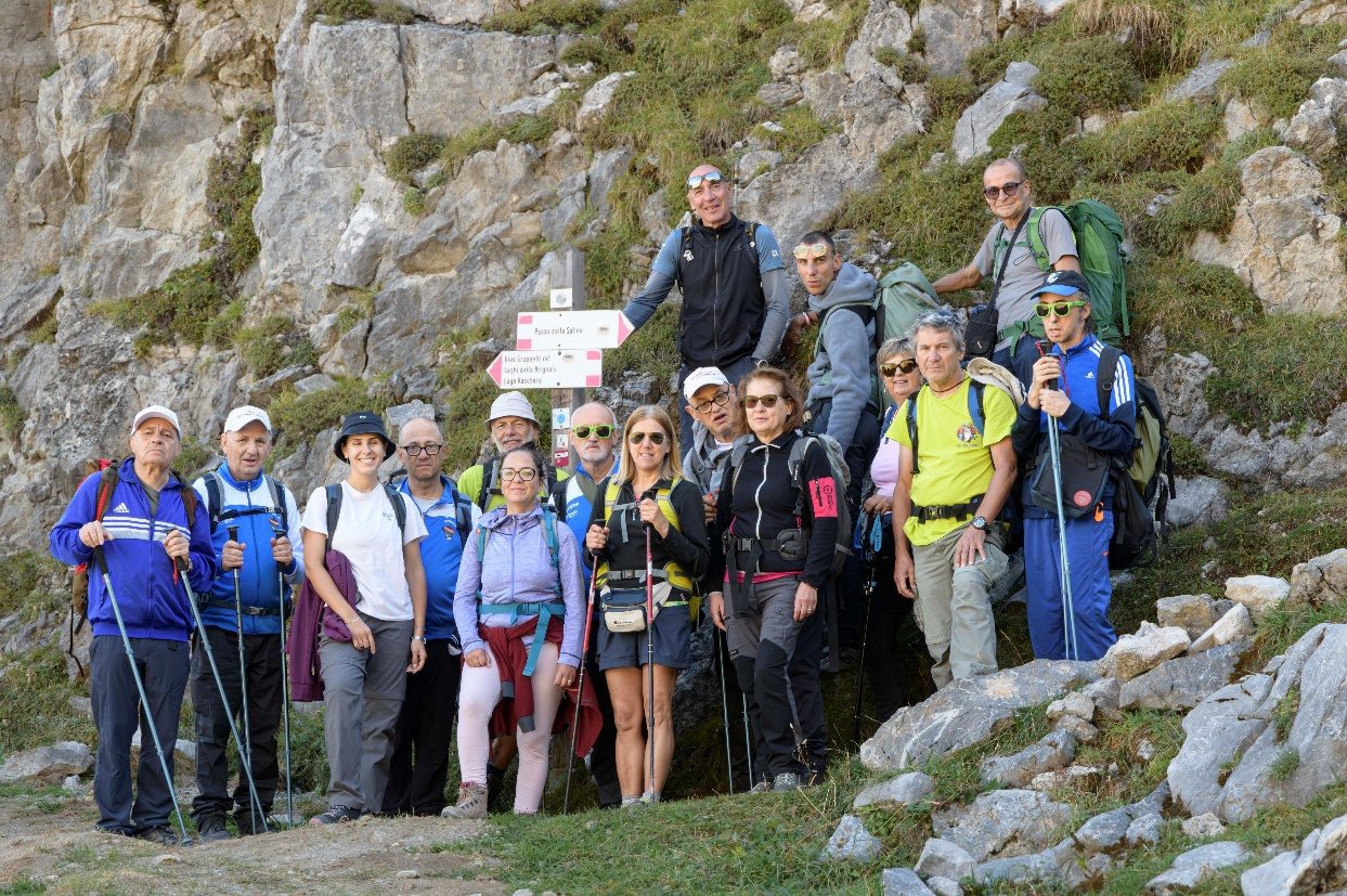 I partecipanti all'escursione lungo il sentiero in Valle Ellero, davanti a un cartello escursionistico